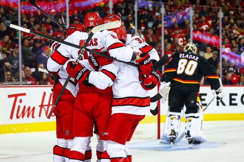 Oct 24, 2024; Calgary, Alberta, CAN; Carolina Hurricanes center Seth Jarvis (24) celebrates his goal with teammates against Calgary Flames goaltender Dan Vladar (80) during the first period at Scotiabank Saddledome. Mandatory Credit: Sergei Belski-Imagn Images