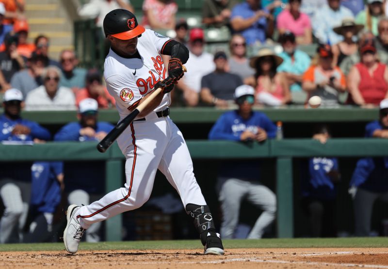 Feb 27, 2025; Sarasota, Florida, USA;  Baltimore Orioles outfielder Ramon Laureano (12) hits an RBI double during the second inning against the Toronto Blue Jays at Ed Smith Stadium. Mandatory Credit: Kim Klement Neitzel-Imagn Images