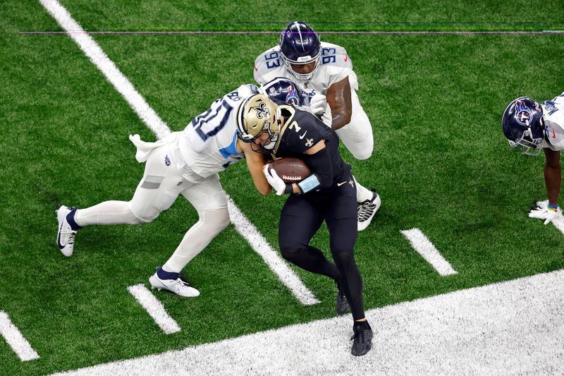 New Orleans Saints tight end Taysom Hill (7) is pushed out of bounds by Tennessee Titans linebacker Jack Gibbens (50) and defensive tackle Teair Tart (93) during an NFL football game, Sunday, Sep. 10, 2023, in New Orleans. (AP Photo/Tyler Kaufman)