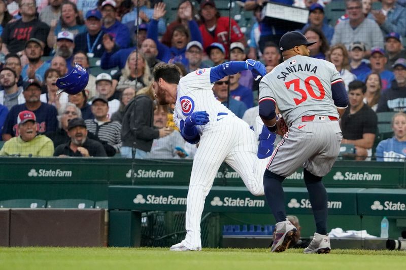 Aug 6, 2024; Chicago, Illinois, USA; Chicago Cubs designated hitter Cody Bellinger (24) beats out an infield single as Minnesota Twins first baseman Carlos Santana (30) covers first base during the first inning at Wrigley Field. Mandatory Credit: David Banks-USA TODAY Sports