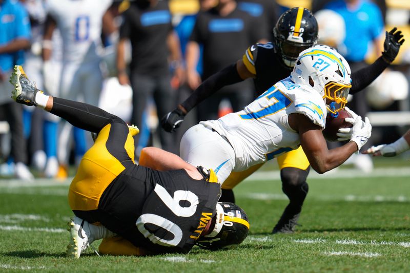 Los Angeles Chargers running back J.K. Dobbins (27) is tackled by Pittsburgh Steelers linebacker T.J. Watt (90) during the second half of an NFL football game, Sunday, Sept. 22, 2024, in Pittsburgh. (AP Photo/Gene J. Puskar)