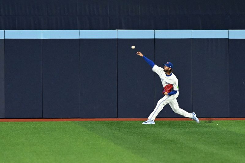 Sep 23, 2025; Toronto, Ontario, CAN;  Toronto Blue Jays starting pitcher Kevin Gausman (34) warms up in the outfield before playing the Boston Red Sox at Rogers Centre. Mandatory Credit: Dan Hamilton-Imagn Images