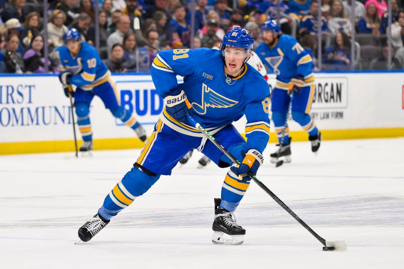 Oct 19, 2024; St. Louis, Missouri, USA;  St. Louis Blues center Dylan Holloway (81) controls the puck against the Carolina Hurricanes during the second period at Enterprise Center. Mandatory Credit: Jeff Curry-Imagn Images