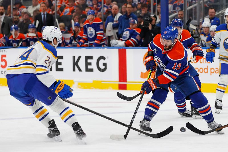 Jan 25, 2025; Edmonton, Alberta, CAN; Buffalo Sabres forward Dylan Cozens (24) and Edmonton Oilers forward Adam Henrique (19) battle for a loose puck during the first period at Rogers Place. Mandatory Credit: Perry Nelson-Imagn Images