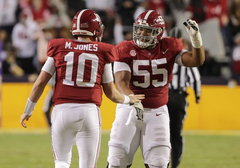 Dec 5, 2020; Baton Rouge, Louisiana, USA; Alabama Crimson Tide quarterback Mac Jones (10) and offensive lineman Emil Ekiyor Jr. (55) celebrate after a touchdown against the LSU Tigers during the second quarter at Tiger Stadium. Mandatory Credit: Derick E. Hingle-USA TODAY Sports