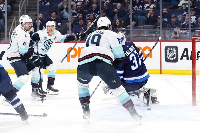 Mar 5, 2024; Winnipeg, Manitoba, CAN; Seattle Kraken defenseman Justin Schultz (4) scores on Winnipeg Jets goaltender Connor Hellebuyck (37) in the first period at Canada Life Centre. Mandatory Credit: James Carey Lauder-USA TODAY Sports