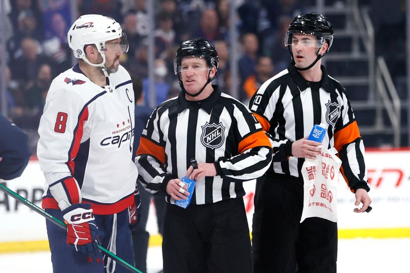 Mar 11, 2024; Winnipeg, Manitoba, CAN; Washington Capitals left wing Alex Ovechkin (8) talks with referee Kelly Sutherland (11) and referee Smith Dunning (20) during a break in the game against the Winnipeg Jets at Canada Life Centre. Mandatory Credit: James Carey Lauder-USA TODAY Sports