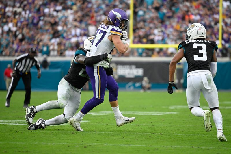 Minnesota Vikings tight end T.J. Hockenson (87) is tackled by Jacksonville Jaguars linebacker Foyesade Oluokun (23) after catching a pass during the second half of an NFL football game, Sunday, Nov. 10, 2024, in Jacksonville, Fla. (AP Photo/Phelan M. Ebenhack)