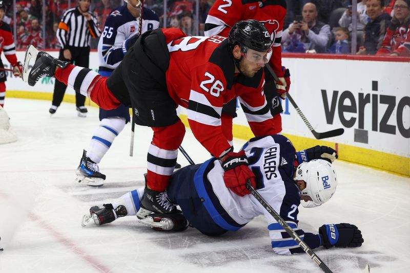 Mar 21, 2024; Newark, New Jersey, USA; New Jersey Devils right wing Timo Meier (28) knocks down Winnipeg Jets left wing Nikolaj Ehlers (27) during the third period at Prudential Center. Mandatory Credit: Ed Mulholland-USA TODAY Sports