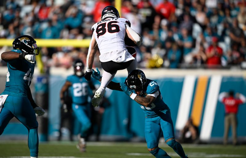 Houston Texans tight end Dalton Schultz (86) leaps over Jacksonville Jaguars cornerback Ronald Darby (25) after a catch during the second half of an NFL football game Sunday, Dec. 1, 2024, in Jacksonville, Fla. (AP Photo/Phelan M. Ebenhack)