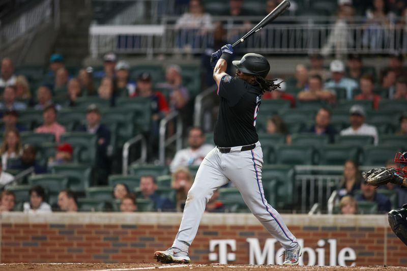 Apr 24, 2024; Atlanta, Georgia, USA; Miami Marlins first baseman Josh Bell (9) reaches on a fielding error against the Atlanta Braves in the ninth inning at Truist Park. Mandatory Credit: Brett Davis-USA TODAY Sports