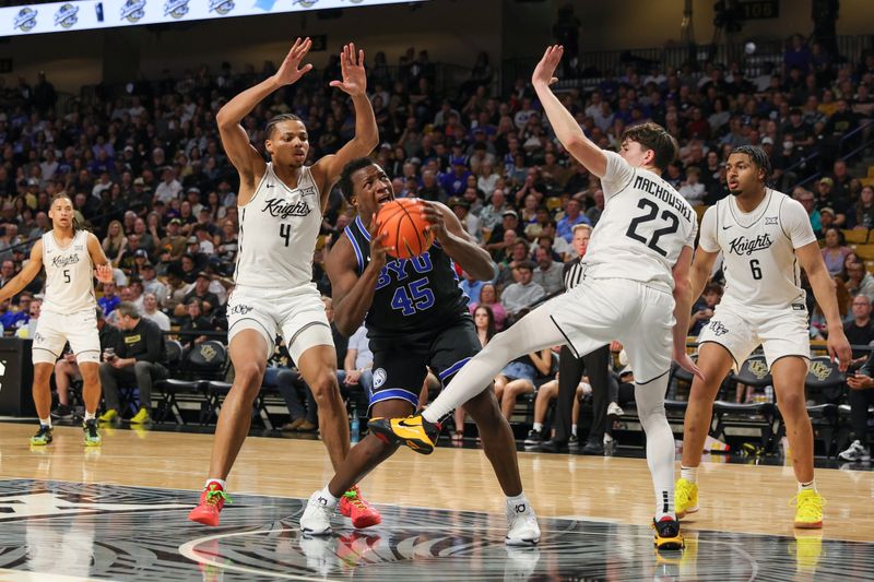 Feb 1, 2025; Orlando, Florida, USA; Brigham Young Cougars center Fousseyni Traore (45) goes to the basket against UCF Knights guard Keyshawn Hall (4) and guard Nils Machowski (22) during the second half at Addition Financial Arena. Mandatory Credit: Mike Watters-Imagn Images