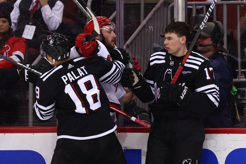 Mar 9, 2024; Newark, New Jersey, USA; Carolina Hurricanes right wing Stefan Noesen (23) and New Jersey Devils defenseman Simon Nemec (17) push and shove during the third period at Prudential Center. Mandatory Credit: Ed Mulholland-USA TODAY Sports