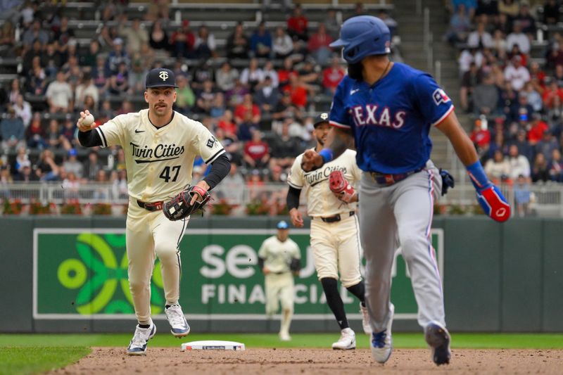May 26, 2024; Minneapolis, Minnesota, USA;  Minnesota Twins infielder Edouard Julien (47) catches Texas Rangers outfielder Derek Hill (40) in a rundown during the sixth inning at Target Field. Mandatory Credit: Nick Wosika-USA TODAY Sports