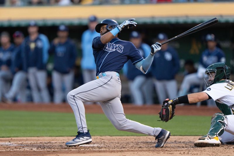 Jun 14, 2023; Oakland, California, USA;  Tampa Bay Rays center fielder Manuel Margot (13) hits an RBI double during the fifth inning against the Oakland Athletics at Oakland-Alameda County Coliseum. Mandatory Credit: Stan Szeto-USA TODAY Sports