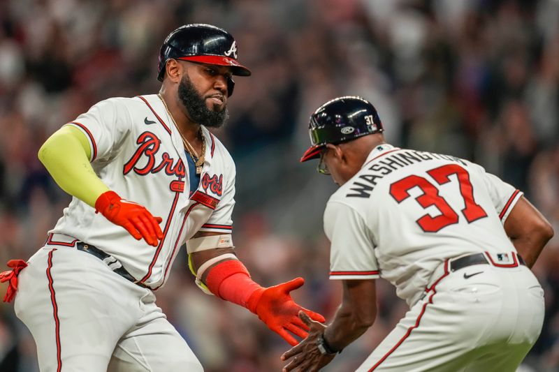 Sep 27, 2023; Cumberland, Georgia, USA; Atlanta Braves designated hitter Marcell Ozuna (20) reacts with third base coach Ron Washington (37) after hitting a home run against the Chicago Cubs during the ninth inning at Truist Park. Mandatory Credit: Dale Zanine-USA TODAY Sports