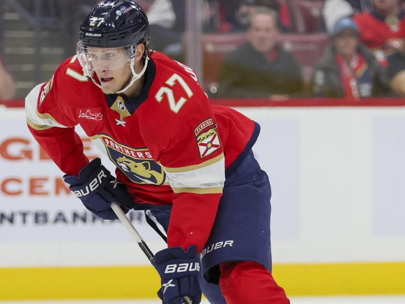 Nov 6, 2023; Sunrise, Florida, USA; Florida Panthers center Eetu Luostarinen (27) moves the puck against the Columbus Blue Jackets during the second period at Amerant Bank Arena. Mandatory Credit: Sam Navarro-USA TODAY Sports