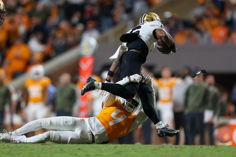 Nov 25, 2023; Knoxville, Tennessee, USA; Tennessee Volunteers defensive back Warren Burrell (4) tackles Vanderbilt Commodores wide receiver Jayden McGowan (6) during the second half at Neyland Stadium. Mandatory Credit: Randy Sartin-USA TODAY Sports