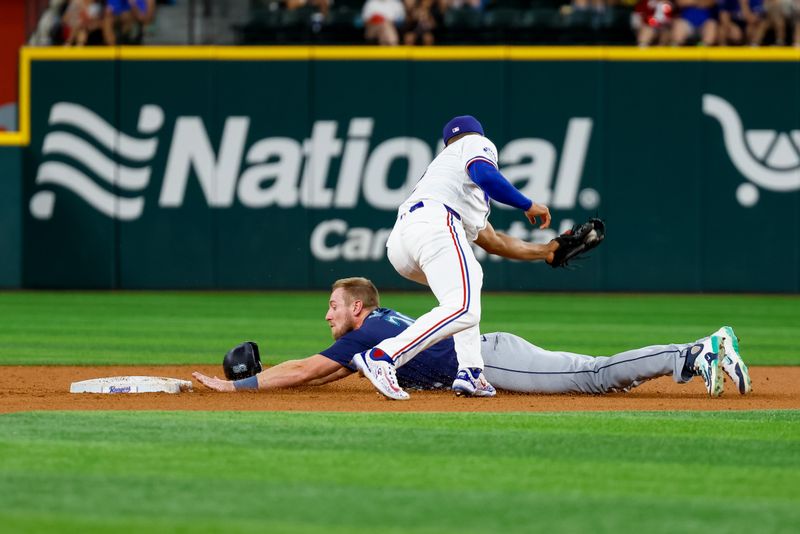 Sep 21, 2024; Arlington, Texas, USA; Seattle Mariners outfielder Luke Raley (20) slides in under a tag by Texas Rangers second base Marcus Semien (2) during the fifth inning but play called dead at Globe Life Field. Mandatory Credit: Andrew Dieb-Imagn Images