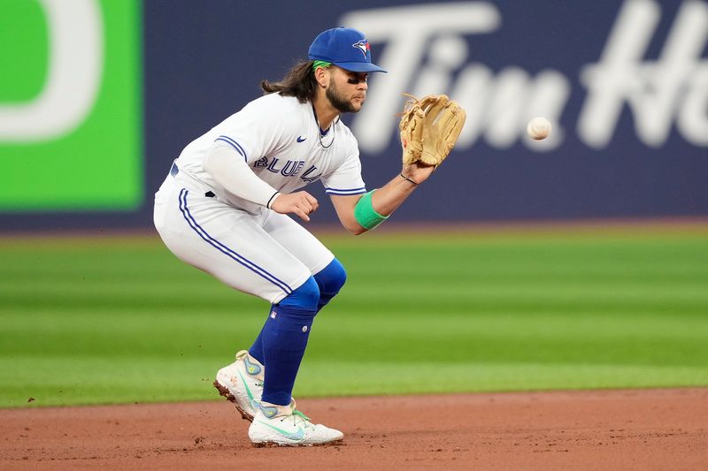 Sep 8, 2023; Toronto, Ontario, CAN; Toronto Blue Jays shortstop Bo Bichette (11) fields a ground ball hit by Kansas City Royals catcher Freddy Fermin (not pictured) during the second inning at Rogers Centre. Mandatory Credit: John E. Sokolowski-USA TODAY Sports