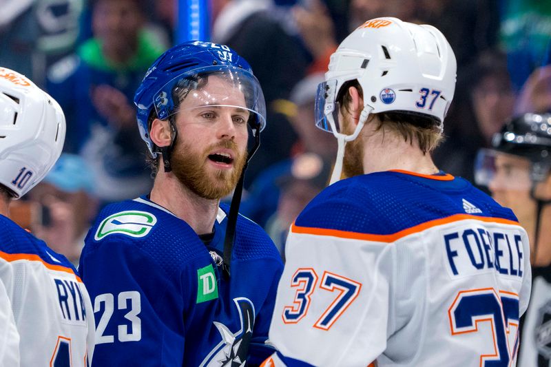 May 20, 2024; Vancouver, British Columbia, CAN; Vancouver Canucks forward Elias Lindholm (23) shakes hands with Edmonton Oilers forward Warren Foegele (37) after the Edmonton victory in game seven of the second round of the 2024 Stanley Cup Playoffs at Rogers Arena. Mandatory Credit: Bob Frid-USA TODAY Sports