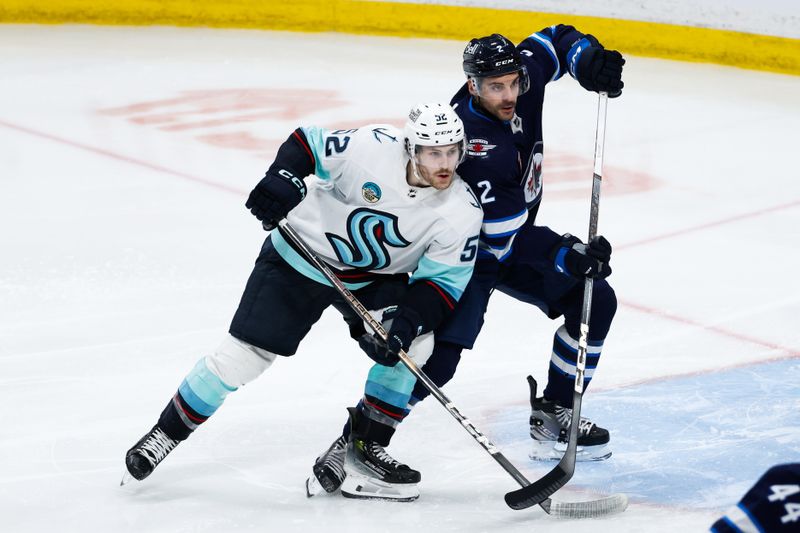 Apr 16, 2024; Winnipeg, Manitoba, CAN;  Winnipeg Jets defenseman Dylan DeMelo (2) jostles for position with Seattle Kraken forward Tye Kartye (52) during the third period at Canada Life Centre. Mandatory Credit: Terrence Lee-USA TODAY Sports