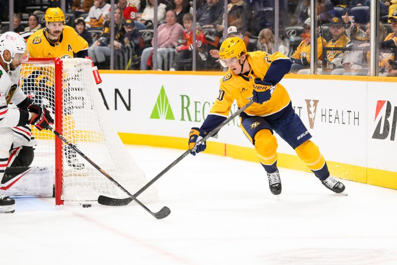 Jan 16, 2025; Nashville, Tennessee, USA;  Nashville Predators defenseman Justin Barron (20) shot goes wide against the Chicago Blackhawks during the third period at Bridgestone Arena. Mandatory Credit: Steve Roberts-Imagn Images