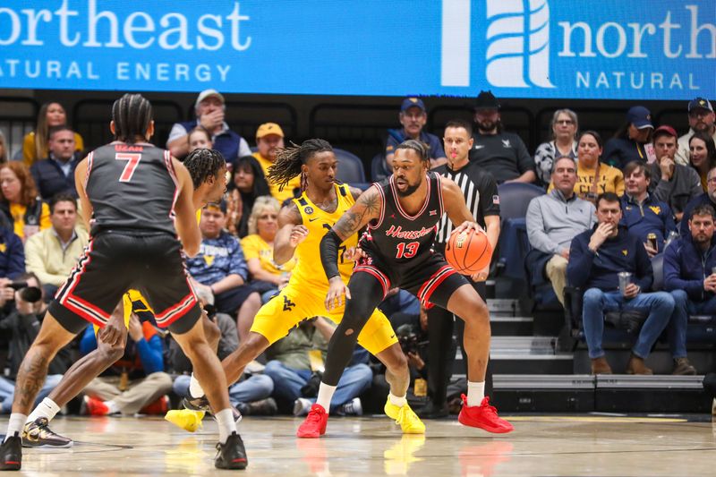 Jan 29, 2025; Morgantown, West Virginia, USA; Houston Cougars forward J'Wan Roberts (13) controls the ball against West Virginia Mountaineers guard Javon Small (7) during the first half at WVU Coliseum. Mandatory Credit: Ben Queen-Imagn Images