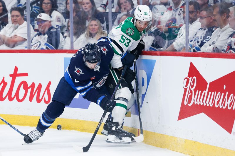 May 7, 2025; Winnipeg, Manitoba, CAN; Winnipeg Jets defenseman Colin Miller (6) battles Dallas Stars forward Wyatt Johnston (53) for the puck during the first period in game one of the second round of the 2025 Stanley Cup Playoffs at Canada Life Centre. Mandatory Credit: Terrence Lee-Imagn Images
