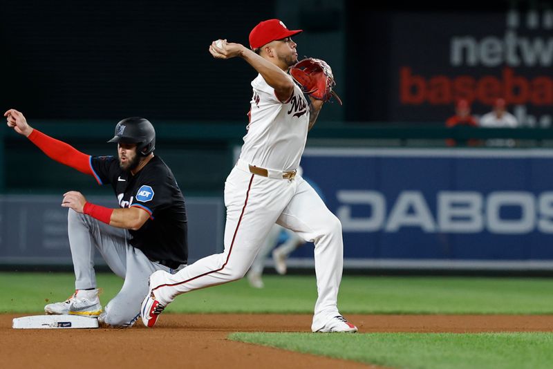 Sep 12, 2024; Washington, District of Columbia, USA; Washington Nationals second baseman Luis García Jr. (2) turns a double play at second base ahead of a slide by Miami Marlins outfielder David Hensley (25) during the seventh inning at Nationals Park. Mandatory Credit: Geoff Burke-Imagn Images