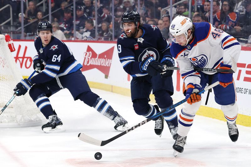 Apr 13, 2025; Winnipeg, Manitoba, CAN; Edmonton Oilers center Noah Philp (48) skates past Winnipeg Jets defenseman Logan Stanley (64) and left wing Alex Iafallo (9) in the first period at Canada Life Centre. Mandatory Credit: James Carey Lauder-Imagn Images