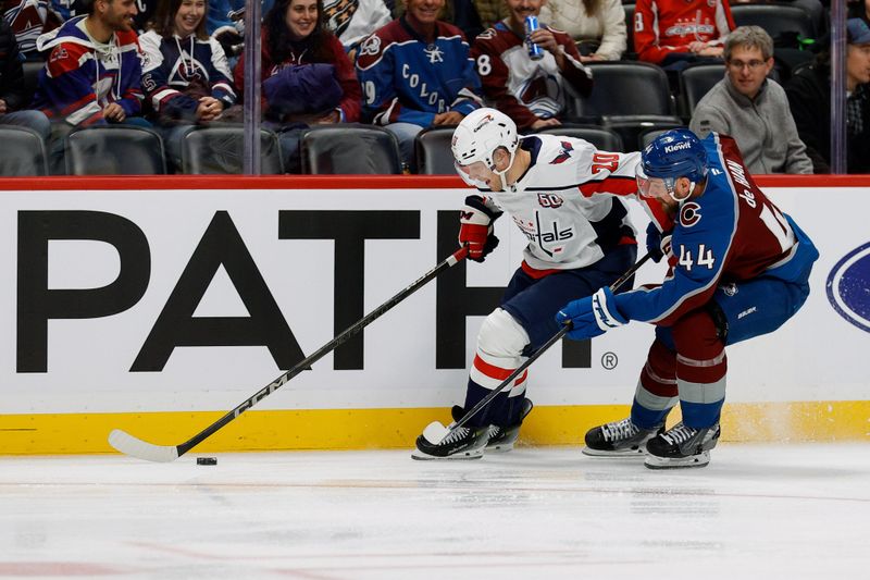 Nov 15, 2024; Denver, Colorado, USA; Washington Capitals center Lars Eller (20) and Colorado Avalanche defenseman Calvin de Haan (44) battle for the puck in the first period at Ball Arena. Mandatory Credit: Isaiah J. Downing-Imagn Images