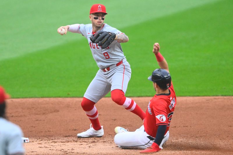 May 3, 2024; Cleveland, Ohio, USA; Los Angeles Angels shortstop Zach Neto (9) looks to throw to first base beside Cleveland Guardians left fielder Steven Kwan (38) in the first inning at Progressive Field. Mandatory Credit: David Richard-USA TODAY Sports