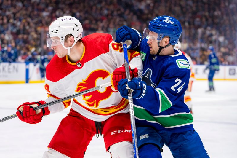 Apr 16, 2024; Vancouver, British Columbia, CAN; Vancouver Canucks forward Pius Suter (24) battles with Calgary Flames defenseman Brayden Pachal (94) in the third period at Rogers Arena. Canucks won 4 -1. Mandatory Credit: Bob Frid-USA TODAY Sports