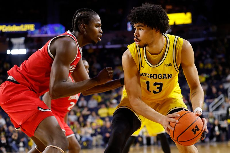 Jan 15, 2024; Ann Arbor, Michigan, USA; Michigan Wolverines forward Olivier Nkamhoua (13) dribbles as Ohio State Buckeyes center Felix Okpara (34) defends in the first half at Crisler Center. Mandatory Credit: Rick Osentoski-USA TODAY Sports