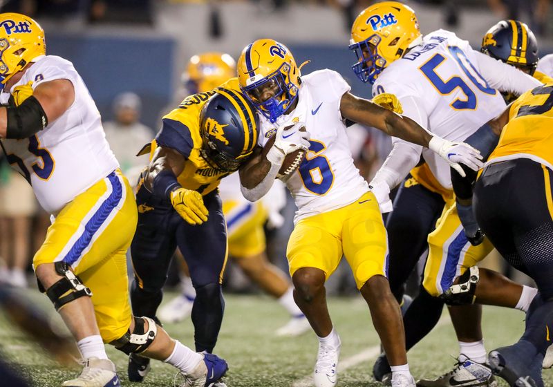 Sep 16, 2023; Morgantown, West Virginia, USA; Pittsburgh Panthers running back Rodney Hammond Jr. (6) runs the ball and is tackled by West Virginia Mountaineers linebacker Lee Kpogba (1) during the first quarter at Mountaineer Field at Milan Puskar Stadium. Mandatory Credit: Ben Queen-USA TODAY Sports