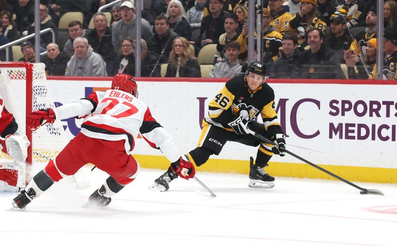 Dec 30, 2025; Pittsburgh, Pennsylvania, USA; Pittsburgh Penguins center Blake Lizotte (46) handles the puck as Carolina Hurricanes left wing Mark Jankowski (77) defends during the first period at PPG Paints Arena. Mandatory Credit: Charles LeClaire-Imagn Images
