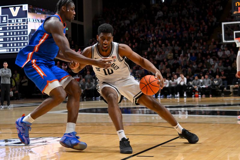 Jan 17, 2026; Nashville, Tennessee, USA;  Vanderbilt Commodores forward Ak Okereke (10) drives to the basket past Florida Gators center Rueben Chinyelu (9) during the second half at Memorial Gymnasium. Mandatory Credit: Steve Roberts-Imagn Images