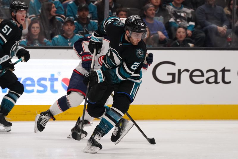 Jan 6, 2026; San Jose, California, USA;  San Jose Sharks center Alexander Wennberg (21) advances the puck against the Columbus Blue Jackets as San Jose Sharks right wing Collin Graf (51) looks on in the third period at SAP Center at San Jose. Mandatory Credit: David Gonzales-Imagn Images