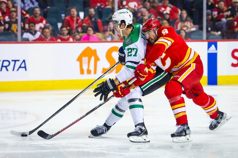 Nov 30, 2023; Calgary, Alberta, CAN; Dallas Stars left wing Mason Marchment (27) and Calgary Flames defenseman Chris Tanev (8) battle for the puck during the third period at Scotiabank Saddledome. Mandatory Credit: Sergei Belski-USA TODAY Sports