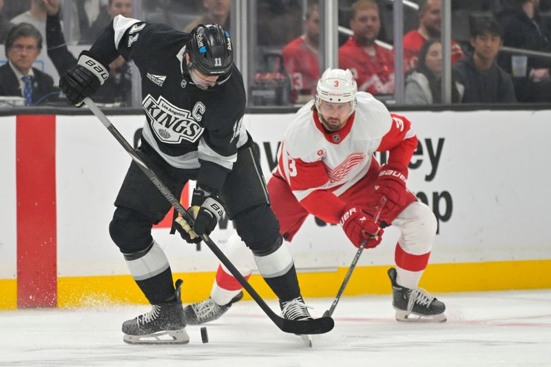 Nov 16, 2024; Los Angeles, California, USA; Los Angeles Kings center Anze Kopitar (11) and Detroit Red Wings defenseman Justin Holl (3) fight for the puck in the first period at Crypto.com Arena. Mandatory Credit: Jayne Kamin-Oncea-Imagn Images