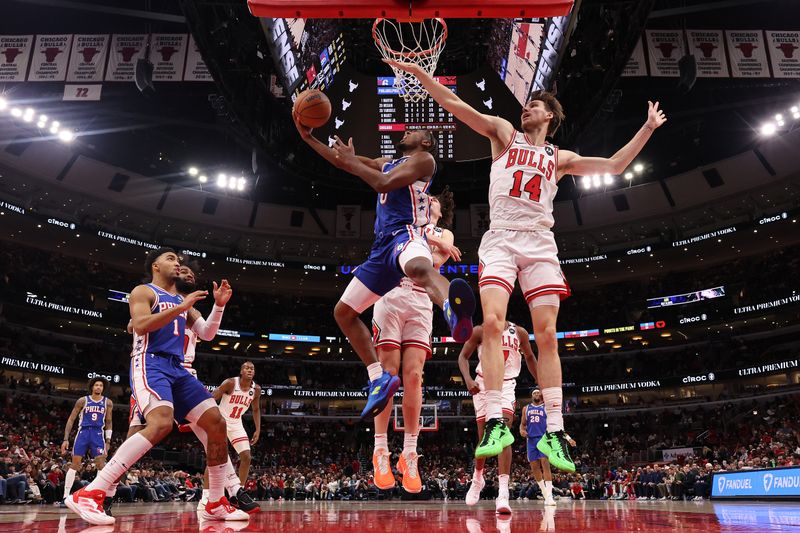 CHICAGO, ILLINOIS - DECEMBER 08: Tyrese Maxey #0 of the Philadelphia 76ers goes up for a layup against Matas Buzelis #14 of the Chicago Bulls during the second half at the United Center on December 08, 2024 in Chicago, Illinois. NOTE TO USER: User expressly acknowledges and agrees that, by downloading and or using this photograph, User is consenting to the terms and conditions of the Getty Images License Agreement.  (Photo by Michael Reaves/Getty Images)