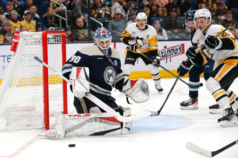 Nov 15, 2024; Columbus, Ohio, USA; Columbus Blue Jackets goalie Elvis Merzlikins (90) makes a pad save as Pittsburgh Penguins left wing Michael Bunting (8) looks for the rebound  during the third period at Nationwide Arena. MandatoryCredit: Russell LaBounty-Imagn Images