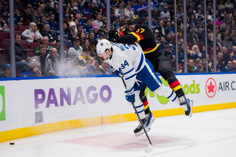 Jan 20, 2024; Vancouver, British Columbia, CAN; Toronto Maple Leafs forward Auston Matthews (34) collides with Vancouver Canucks defenseman Tyler Myers (57) in the second period at Rogers Arena. Mandatory Credit: Bob Frid-USA TODAY Sports