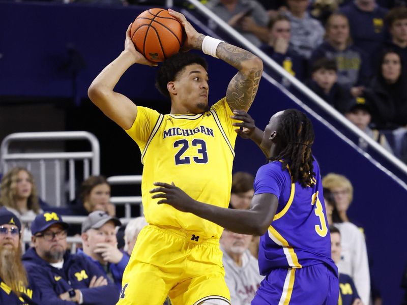 Dec 29, 2025; Ann Arbor, Michigan, USA;  Michigan Wolverines forward Yaxel Lendeborg (23) is defended by McNeese Cowboys guard Garwey Dual (3) in the first half at Crisler Center. Mandatory Credit: Rick Osentoski-Imagn Images