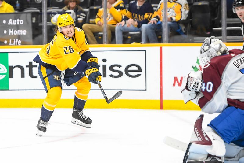 Nov 20, 2023; Nashville, Tennessee, USA;  Nashville Predators defenseman Philip Tomasino (26) takes a shot on goal against the Colorado Avalanche during the third period at Bridgestone Arena. Mandatory Credit: Steve Roberts-USA TODAY Sports