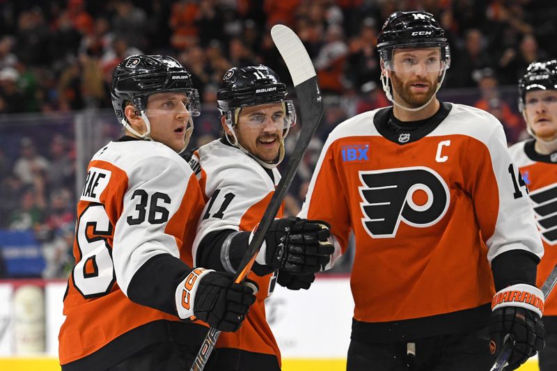 Nov 11, 2024; Philadelphia, Pennsylvania, USA; Philadelphia Flyers right wing Travis Konecny (11) celebrates his goal with defenseman Emil Andrae (36) and center Sean Couturier (14) against the San Jose Sharks during the first period at Wells Fargo Center. Mandatory Credit: Eric Hartline-Imagn Images