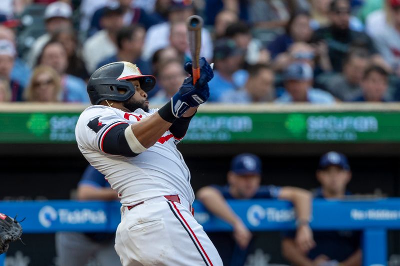 Jun 19, 2024; Minneapolis, Minnesota, USA; Minnesota Twins first baseman Carlos Santana (30) hits a single against the Tampa Bay Rays in the fourth inning at Target Field. Mandatory Credit: Jesse Johnson-USA TODAY Sports