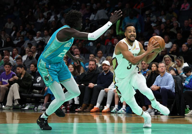 CHARLOTTE, NORTH CAROLINA - DECEMBER 15:  CJ McCollum #3 of the New Orleans Pelicans drives to the basket against JT Thor #21 of the Charlotte Hornets during the first period of the game at Spectrum Center on December 15, 2023 in Charlotte, North Carolina. NOTE TO USER: User expressly acknowledges and agrees that, by downloading and or using this photograph, User is consenting to the terms and conditions of the Getty Images License Agreement. (Photo by Jared C. Tilton/Getty Images)