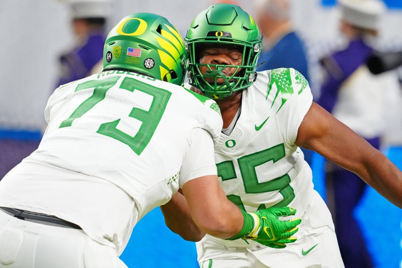 Dec 1, 2023; Las Vegas, NV, USA; Oregon Ducks offensive lineman Ajani Cornelius (65) warms up with Oregon Ducks offensive lineman Kawika Rogers (73) before a game against the Washington Huskies at Allegiant Stadium. Mandatory Credit: Stephen R. Sylvanie-USA TODAY Sports